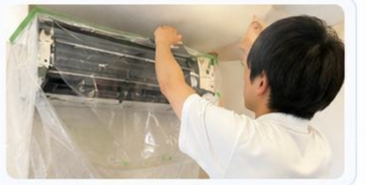 エアコン周りにビニールで養生するスタッフ