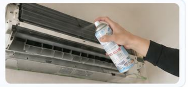 エアコン内部に抗菌消臭剤を吹きかけるスタッフ